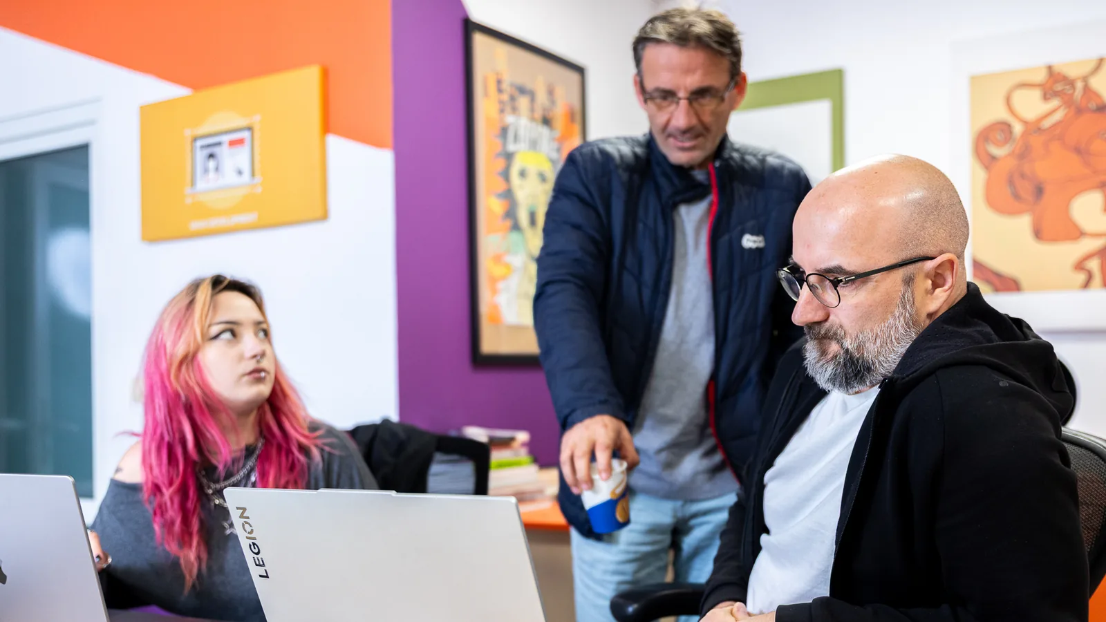 Drei Mitglieder des REEA-Teams besprechen ein Projekt am Laptop im Entwicklungszentrum