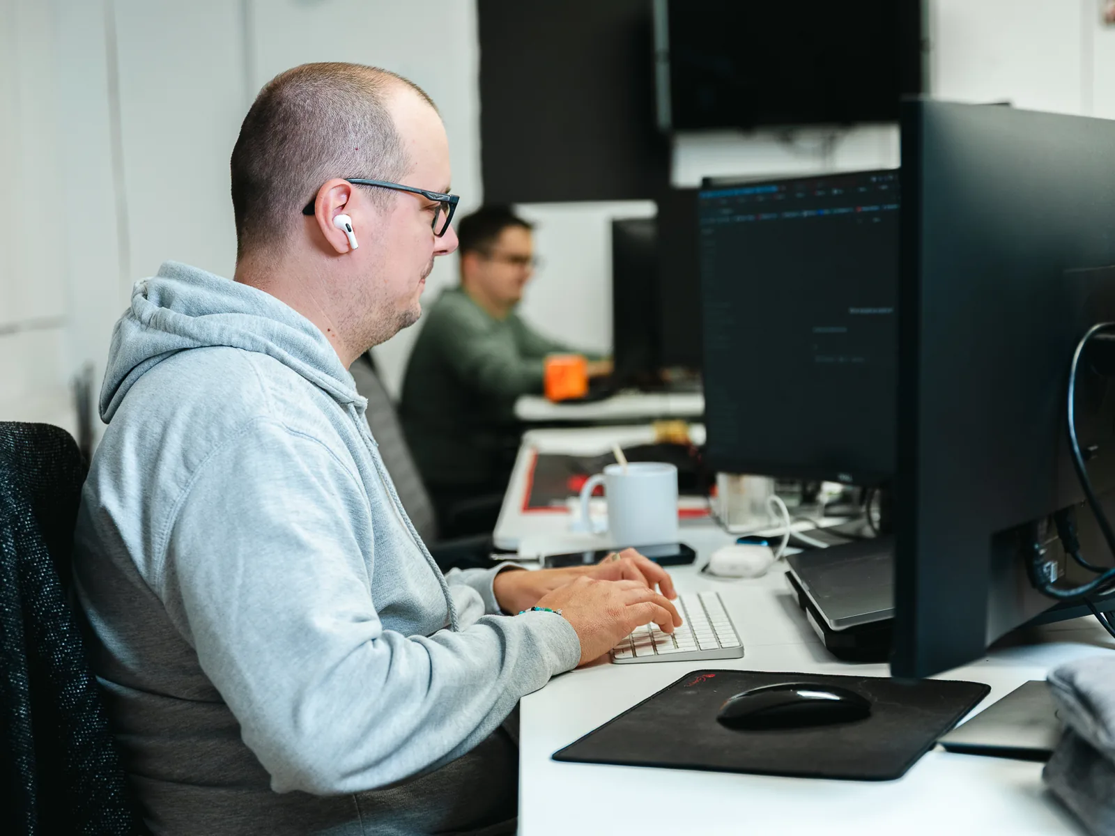 Entwickler von REEA arbeitet an mehreren Bildschirmen mit Programmcode